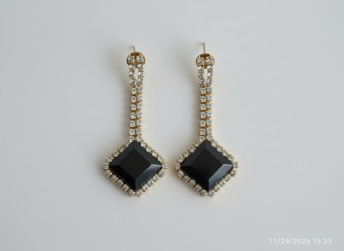 Black square stones and gold accents.